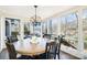 Bright dining room with walls of windows overlooking the lake, and a classic wooden table with black chairs at 353 Whippoorwill Rd, Mooresville, NC 28117
