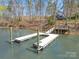 Picturesque dock extending into the water, with a walkway leading to a charming house on the waterfront at 353 Whippoorwill Rd, Mooresville, NC 28117
