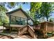 Charming home exterior with glass windows, wooden deck, steps, mature trees, and gravel landscaping at 353 Whippoorwill Rd, Mooresville, NC 28117