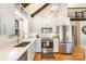 Modern kitchen with white subway tile backsplash, stainless steel appliances, and ample cabinet space, plus large sink and window at 353 Whippoorwill Rd, Mooresville, NC 28117