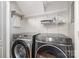 A well-lit laundry room featuring a modern Samsung washer and dryer with convenient shelving for storage at 353 Whippoorwill Rd, Mooresville, NC 28117