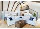 Open concept living room with a vaulted ceiling, exposed beams, and views of the modern kitchen and staircase at 353 Whippoorwill Rd, Mooresville, NC 28117