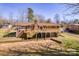 An elevated back view of a charming brick house with a large deck and serene backyard at 3617 12Th Street Ne Dr, Hickory, NC 28601