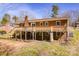 View of a brick house with a wooden deck, yard and trees at 3617 12Th Street Ne Dr, Hickory, NC 28601