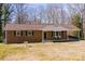 Charming brick ranch-style home with a covered porch and mature trees on a sunny day at 3617 12Th Street Ne Dr, Hickory, NC 28601
