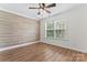 Bright bedroom with wood accent wall, hardwood floors, and a window overlooking the outdoors at 4053 Crestview Dr, Rock Hill, SC 29732