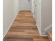 Hallway with hardwood floors leading to a white front door, stairs, and white trim at 4116 Lurelin Ln, Charlotte, NC 28262