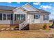 Charming single-story home with brick foundation, gray siding, and a welcoming front porch with white railings at 447 Lookout Dam Rd, Statesville, NC 28625