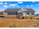 Charming single-story home with gray siding, black shutters, and landscaped front yard under a partly cloudy sky at 447 Lookout Dam Rd, Statesville, NC 28625
