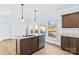 Bright kitchen island with stainless steel appliances, pendant lights, and wood flooring at 447 Lookout Dam Rd, Statesville, NC 28625