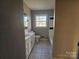 Bathroom with a tiled floor, white vanity, and a bathtub with white and black tiled walls at 6705 Edenwood Pl, Charlotte, NC 28212