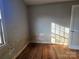 Bedroom featuring hardwood floors, natural light, and damaged walls in need of repair at 6705 Edenwood Pl, Charlotte, NC 28212