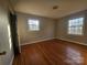 Bedroom with hardwood floors, two windows for natural light, and closet showing the room's layout at 6705 Edenwood Pl, Charlotte, NC 28212