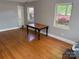 Light-filled bedroom with hardwood floors and two large windows showcasing the outdoors at 7107 Wilson Grove Rd, Mint Hill, NC 28227