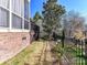 Fenced backyard featuring a brick home exterior, manicured lawn, and mature trees at 7509 Thorn Creek Ln, Tega Cay, SC 29708