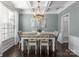 Bright dining room with a modern chandelier, stylish furniture, and wainscoting at 7720 Dinniston Dr, Huntersville, NC 28078