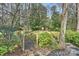 Charming backyard featuring a quaint wooden bridge, lush greenery and a wooded area at 830 Jefferson Dr, Charlotte, NC 28270