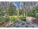 A tranquil backyard featuring a wooden bridge, gravel pathway, and a swing for outdoor relaxation at 830 Jefferson Dr, Charlotte, NC 28270