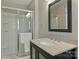 This bathroom features a glass shower and a granite vanity with a black framed mirror at 830 Jefferson Dr, Charlotte, NC 28270