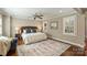 Main bedroom features a bed with a plush rug, windows with plantation shutters and hardwood floors at 830 Jefferson Dr, Charlotte, NC 28270