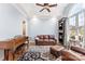 Bright living room featuring hardwood floors, a piano, and a comfortable leather sofa under a decorative ceiling fan at 103 Caddies Ct, Shelby, NC 28150