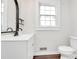 Bathroom featuring modern vanity, mirror, and toilet with hardwood floors at 1101 Lancaster Ave, Monroe, NC 28112