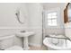 Bathroom featuring a clawfoot tub, pedestal sink, and neutral finishes at 1101 Lancaster Ave, Monroe, NC 28112