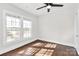 Bright bedroom with wood floors, a ceiling fan, and two large windows at 1101 Lancaster Ave, Monroe, NC 28112