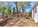Wooden deck with wrought iron railing, lush plants, and an outdoor fire pit at 1101 Lancaster Ave, Monroe, NC 28112