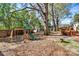 Backyard playground with swings, a slide, mature trees, and a wooden privacy fence at 1101 Lancaster Ave, Monroe, NC 28112