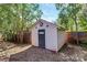 A Shed is situated in the backyard near trees and a wooden fence at 1101 Lancaster Ave, Monroe, NC 28112