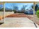 View of a spacious backyard with a wooden deck, detached garage, and mature trees at 112 Lentz St, Rockwell, NC 28138