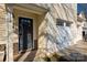 Inviting front entry with a dark door, sidelight, brick accents, and a two-car garage on a sunny day at 117 Richland Ln, Mooresville, NC 28115