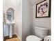 Powder room featuring a pedestal sink, oval mirror, and stylish artwork at 121 Edgehill Ct, Troutman, NC 28166