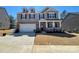 Charming two-story home with a brick and siding exterior, front porch, and a two-car garage at 121 Edgehill Ct, Troutman, NC 28166