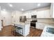 Well-lit kitchen with stainless steel appliances, granite countertops, and an island with bar stool seating at 121 Edgehill Ct, Troutman, NC 28166