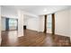 An open living room with wood floors, neutral walls, a fireplace, and large windows with nice curtains at 121 Edgehill Ct, Troutman, NC 28166