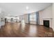 Spacious open-concept living area with wood floors, a fireplace, and a view into a kitchen at 121 Edgehill Ct, Troutman, NC 28166