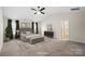 Staged main bedroom features vaulted ceiling, ceiling fan, carpet flooring, and ensuite bathroom entrance at 121 Edgehill Ct, Troutman, NC 28166