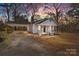 Charming cottage-style home with a covered carport and inviting front porch, surrounded by mature trees at 1216 Innis Ave, Kannapolis, NC 28081