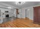 Open layout showcasing a modern kitchen with stainless steel appliances, white cabinets, and hardwood floors at 1216 Innis Ave, Kannapolis, NC 28081