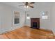 Cozy living room featuring hardwood floors, a brick fireplace, and natural light from the windows at 1216 Innis Ave, Kannapolis, NC 28081