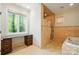 Beautiful bathroom with a walk-in shower, a soaking tub, and travertine tile at 12702 Overlook Mountain Dr, Charlotte, NC 28216