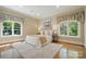 Bright bedroom featuring a comfortable bed, hardwood floors, and two windows with decorative curtains at 12702 Overlook Mountain Dr, Charlotte, NC 28216