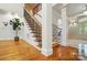 Grand foyer with a wooden staircase, elegant pillars, and hardwood flooring creating a welcoming entrance at 12702 Overlook Mountain Dr, Charlotte, NC 28216