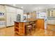 Open-concept kitchen featuring an island with bar seating, stainless steel appliances, and hardwood floors at 12702 Overlook Mountain Dr, Charlotte, NC 28216