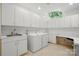 Laundry room features ample white cabinets, sink, washer, dryer and desk area at 12702 Overlook Mountain Dr, Charlotte, NC 28216