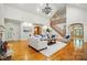Open living room with staircase, hardwood floors, built-in shelving, and ample seating space at 12702 Overlook Mountain Dr, Charlotte, NC 28216