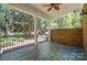 Spacious brick patio with ceiling fan, columns and outdoor seating area overlooking manicured yard at 12702 Overlook Mountain Dr, Charlotte, NC 28216