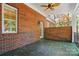 Outdoor patio features brick walls, ceiling fan and serene backyard views at 12702 Overlook Mountain Dr, Charlotte, NC 28216